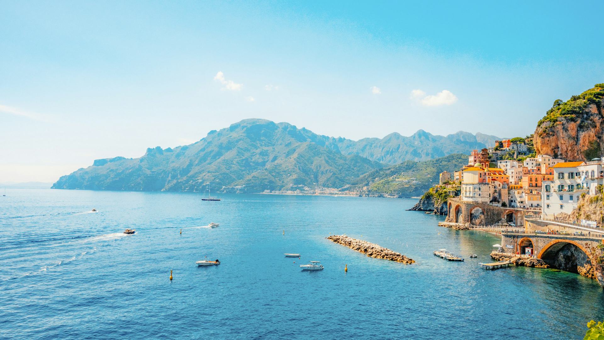 Coastline in Italy with shot of cliffside buildings & ocean.